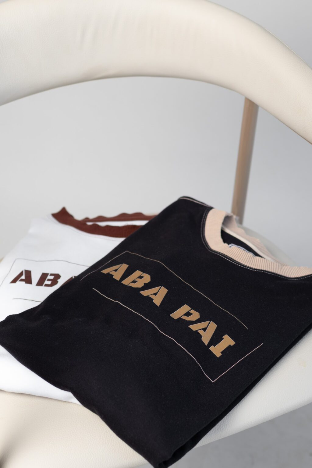 Camiseta Aba Pai preta dobrada sobre uma cadeira
