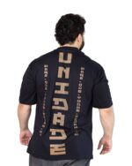 Modelo de costas com a Camiseta Oversized Unidade preta e estampa vertical dourada